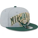 cappellino-piatto-grigio-e-verde-snapback-9fifty-tip-off-2023-dei-milwaukee-bucks-nba-di-new-era